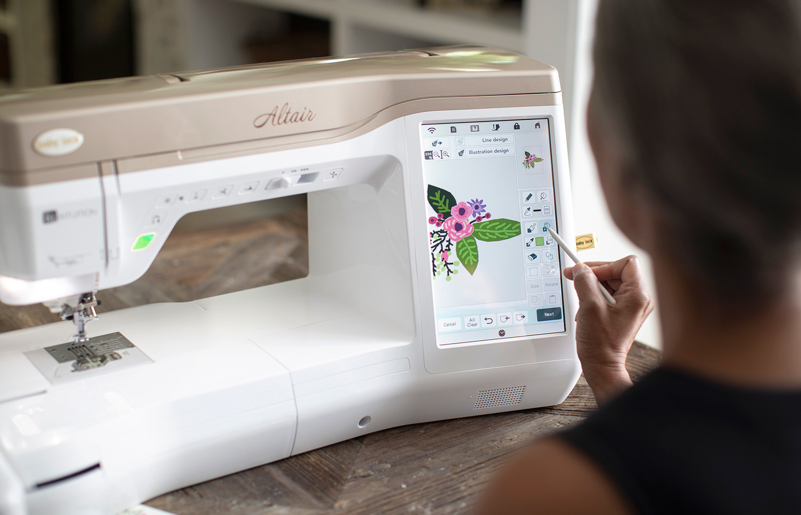 A person sitting at the Baby Lock Altair sewing and embroidery machine editing a design on the screen. 